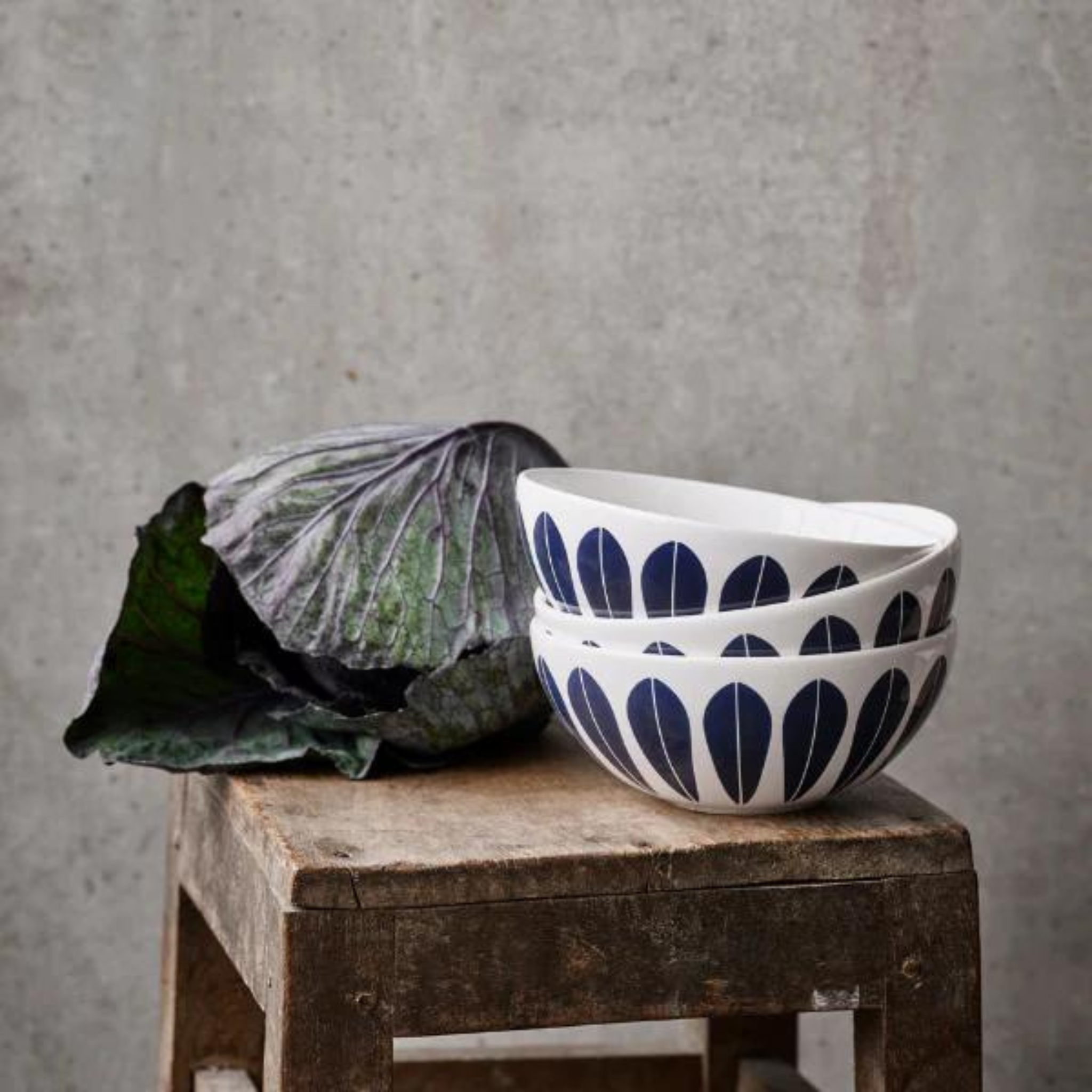 White and Blue glazed bowl with a lotus flower-inspired design by Arne Clausen. The bowl features a repeating pattern of lotus petals arranged in a circular pattern under the the bowl. 